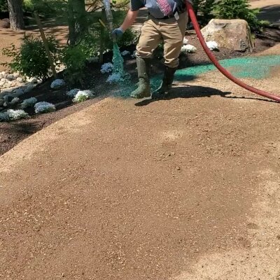 Worker applying hydroseed mixture to lawn in Washington State.