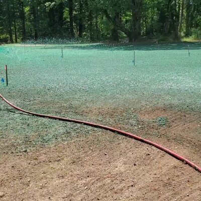 Hydroseeding process with spray hose on new lawn in Washington state.