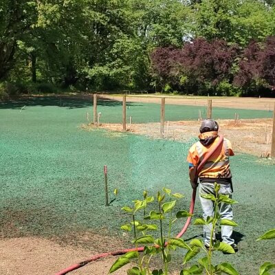 Worker hydroseeding new lawn in Washington State.