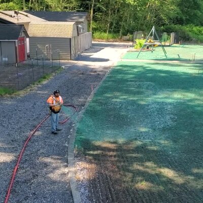 Worker applying hydroseed mixture on lawn in Washington state.