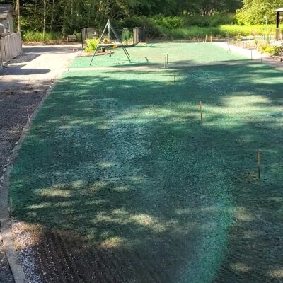 "Fresh hydroseeding on residential lawn with swing set in Washington State"