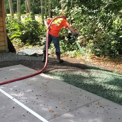 Worker applying hydroseed on ground in Washington.