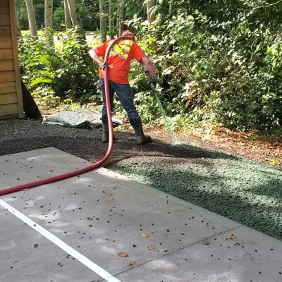 Worker applying hydroseed mixture on lawn in Washington State.