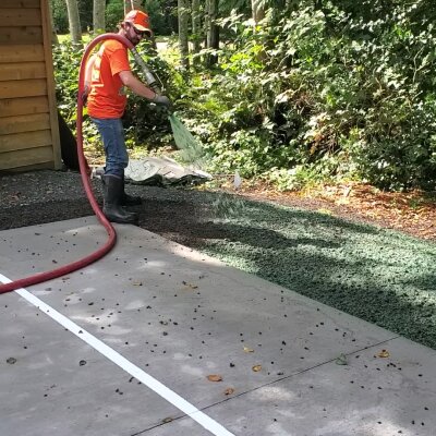 Hydroseed installer applying mixture on lawn in Washington State.