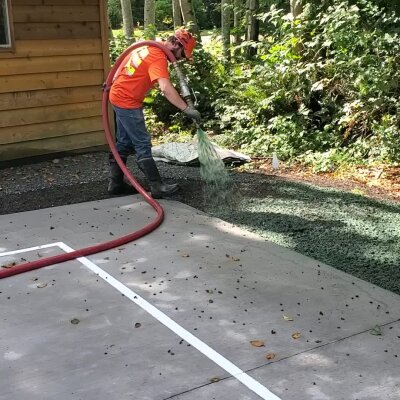 Worker applying hydroseed mix on soil in Washington state.